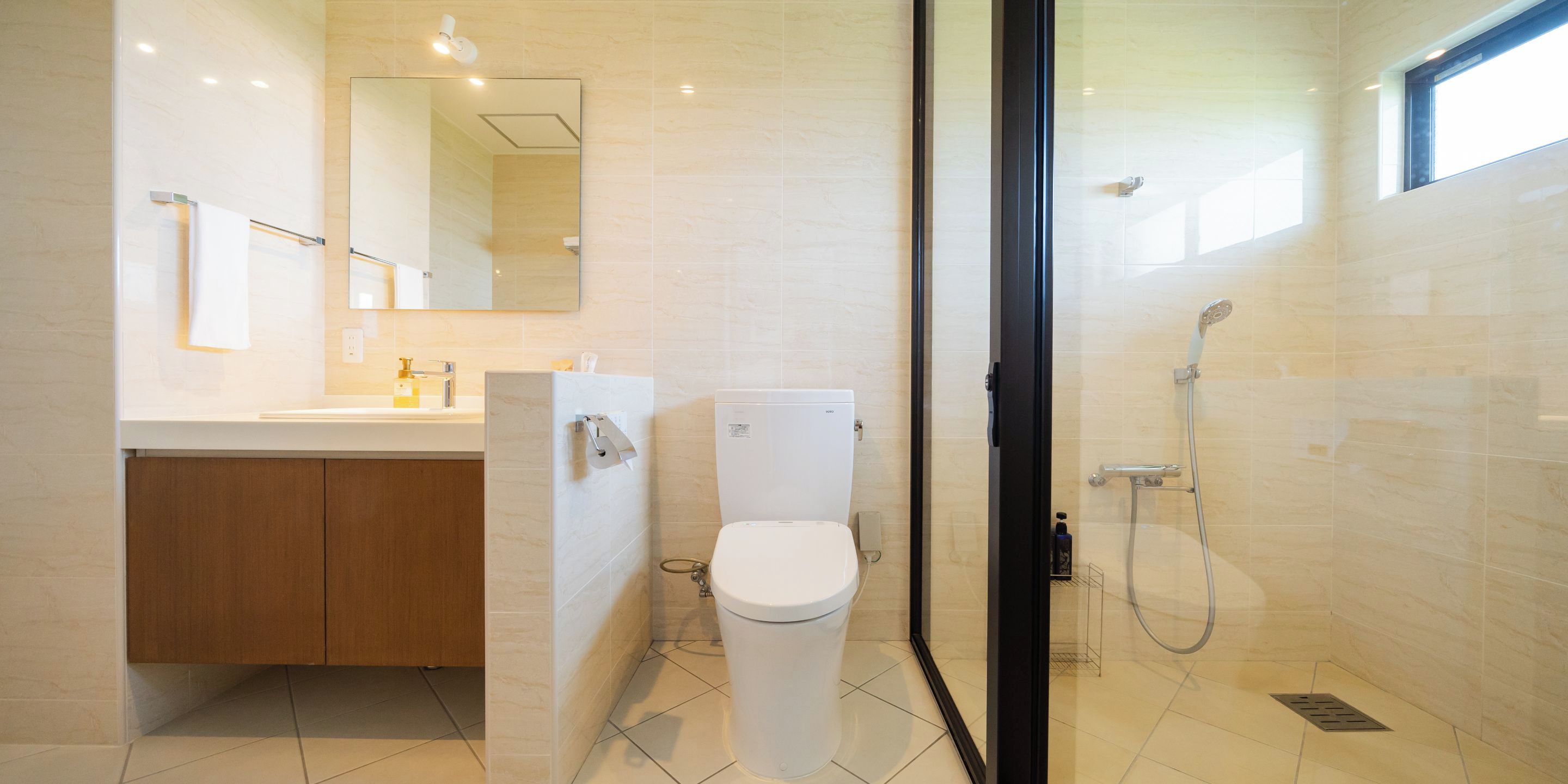 A modern bathroom with a toilet, sink, and shower.