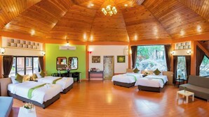 A hotel room with two beds, a desk, a chair, and a sofa. The room has wooden floors and a wooden ceiling. - Bhumisiri Hill Khaoyai (Pak Chong)