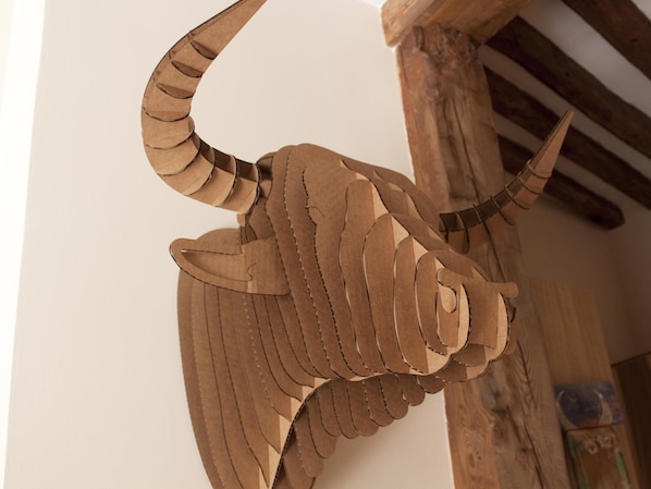 A large, intricately designed paper sculpture of a bird, possibly a dinosaur, mounted on a wooden structure.