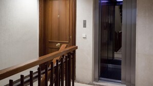 Een houten deur en een lift in een gang.