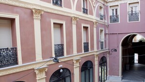 Fachada de edificio con ventanas de arco y molduras decorativas.