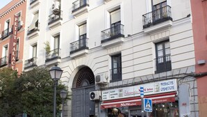 Un edificio con una fachada que muestra el letrero "Peluquería N. Belleza" y un anuncio de "Productos Cosméticos".