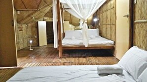 A room with a bed under a canopy, a wooden floor, and a door leading to another room. - V House (San Pablo)