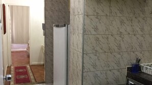 A compact kitchen with a built-in oven, a refrigerator, and a microwave. - Copacabana Ocean Breeze (Rio de Janeiro)