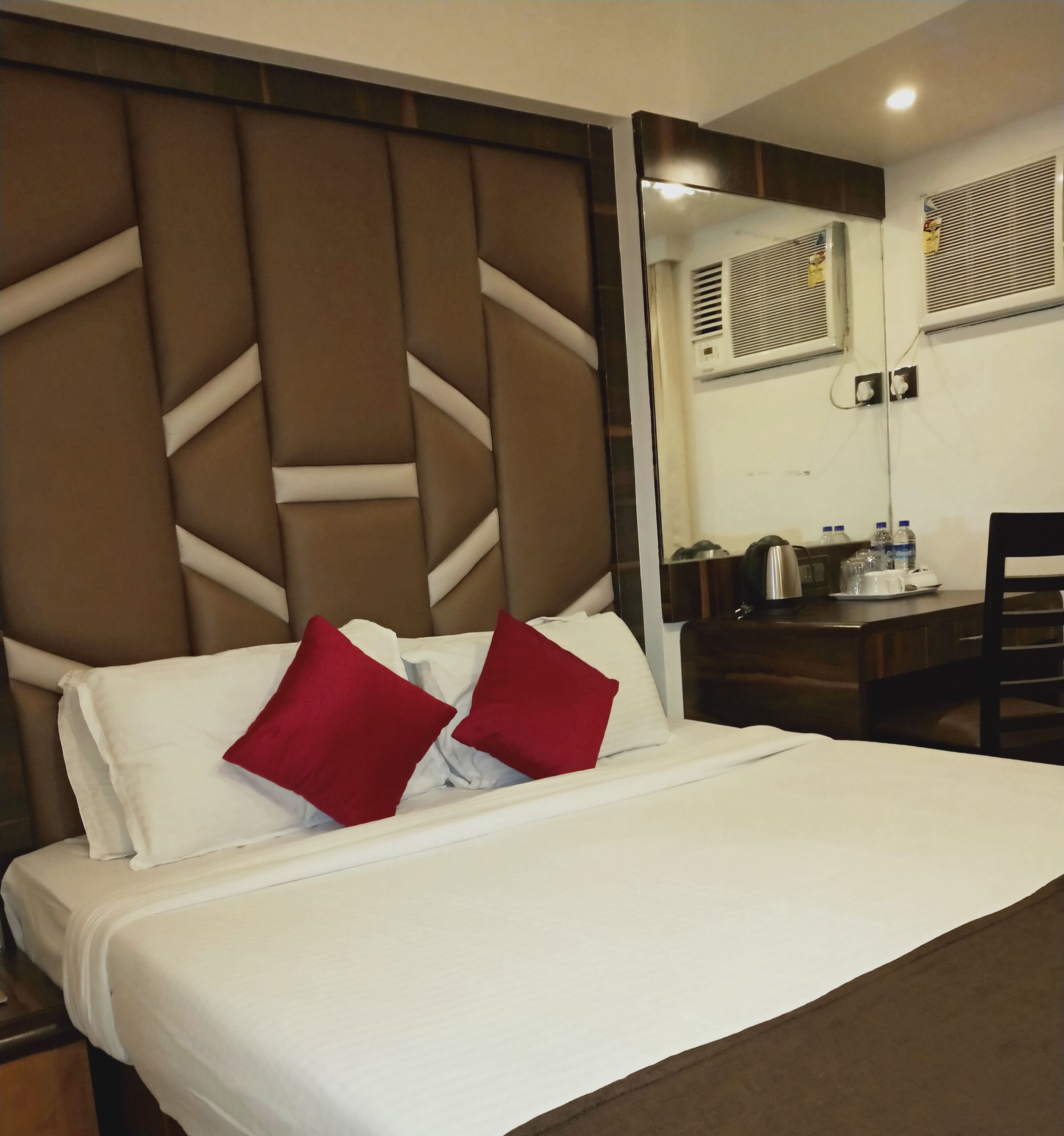 Una habitación de hotel con cama, escritorio y una silla.