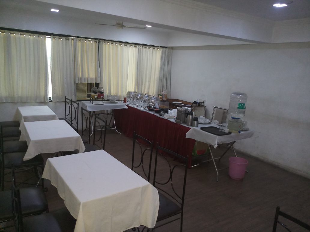 A conference room with tables, chairs, and a water dispenser.