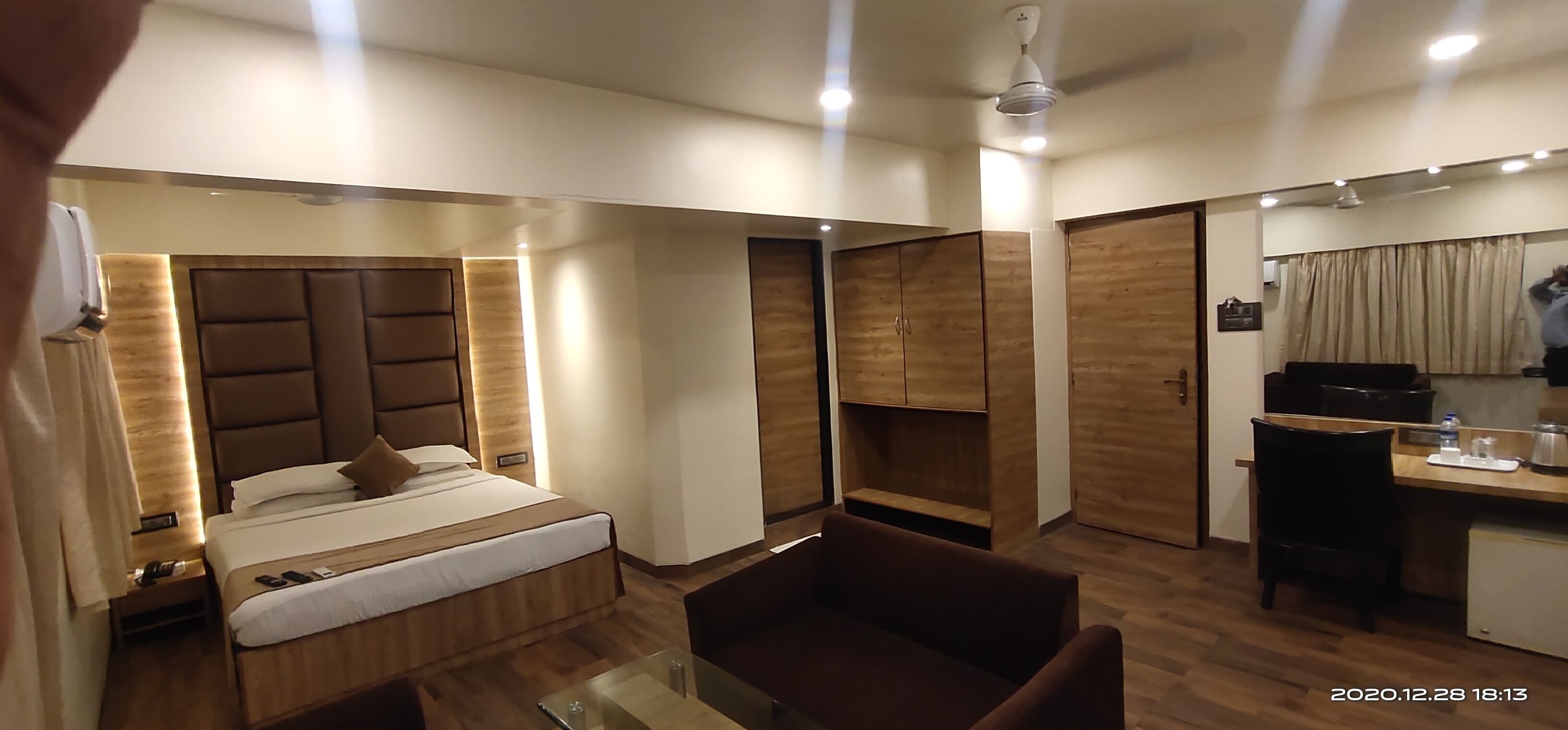 Een moderne hotelkamer met een bed, een bureau, een stoel en een kledingkast.