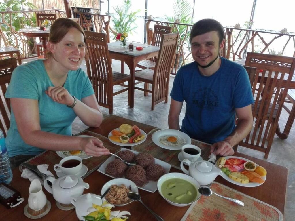 A dining table with various dishes, including a plate of eggs, a bowl of soup, and a cup of coffee.