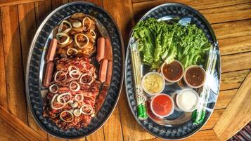 Two oval-shaped plates with food items on a wooden table.