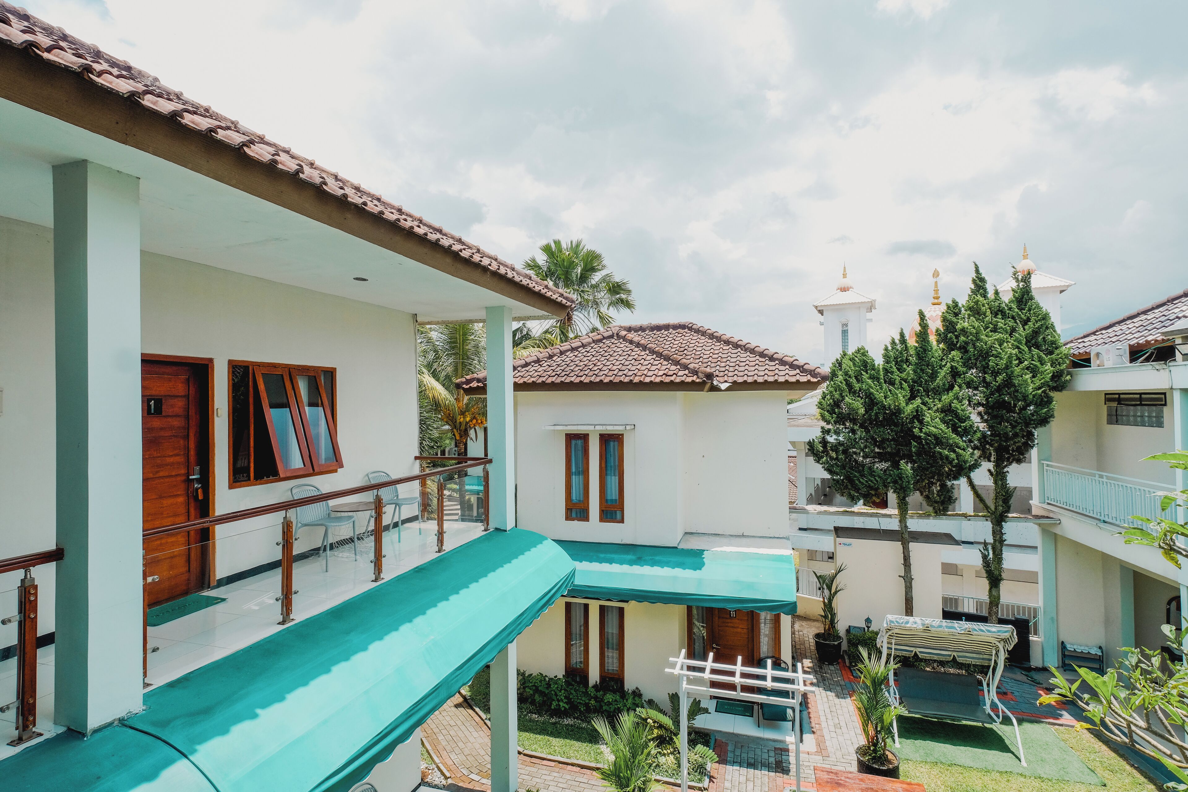 A multi-story building with a covered outdoor area, a staircase, and a pool.