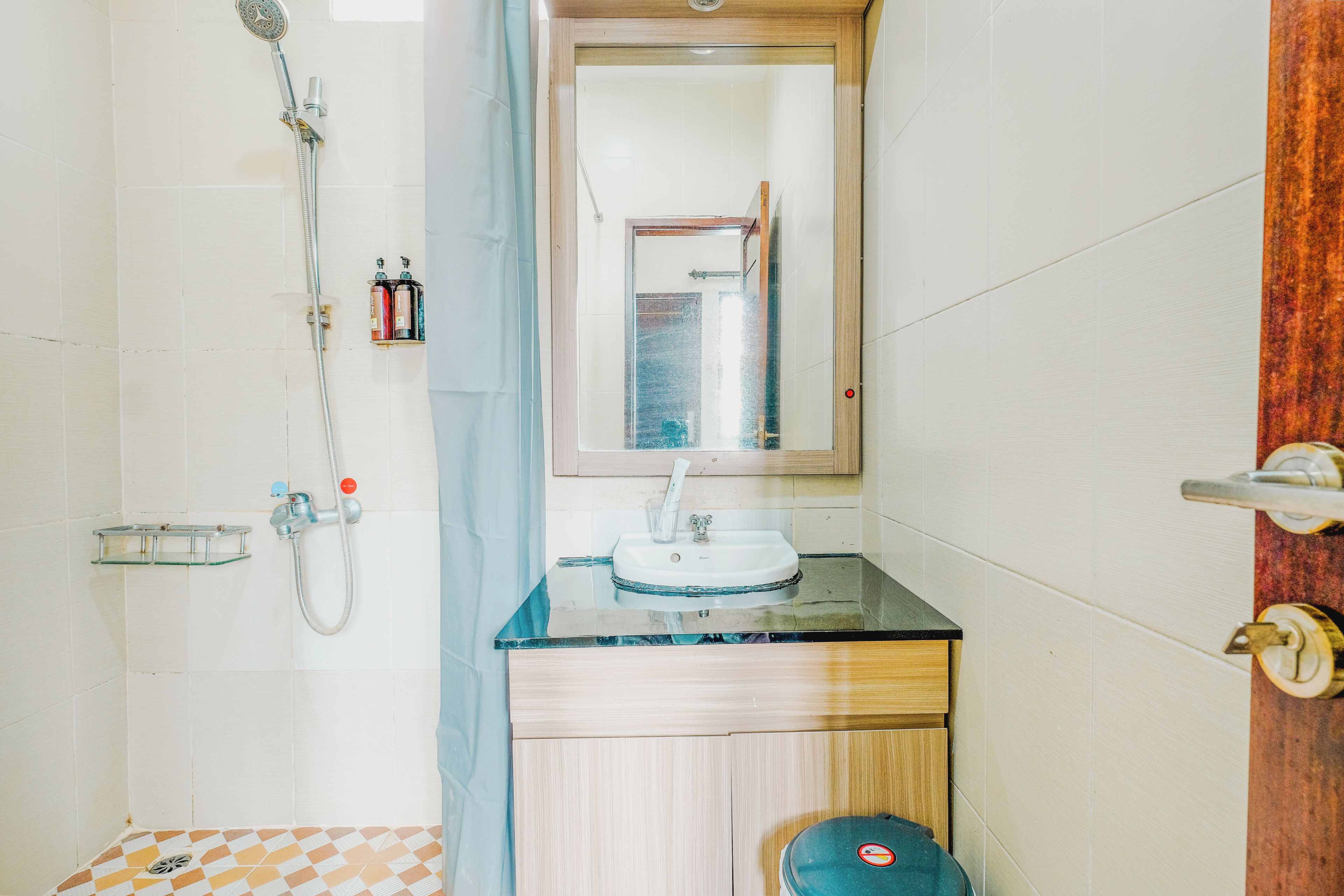 Ein Badezimmer mit Dusche, Waschbecken und Spiegel.