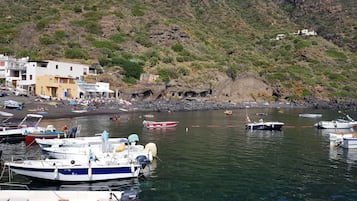 In StrandnĂ€he, schwarzer Sandstrand, Sonnenschirme, StrandtĂŒcher
