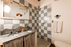 Ein Badezimmer mit einer Wand aus Schachbrettfliesen, einem Waschbecken mit Handtuchhalter und einer Toilette.