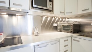 A modern kitchen with stainless steel appliances, a built-in microwave, and a toaster oven. - Imperial Deluxe Plaza Mayor (Madrid)