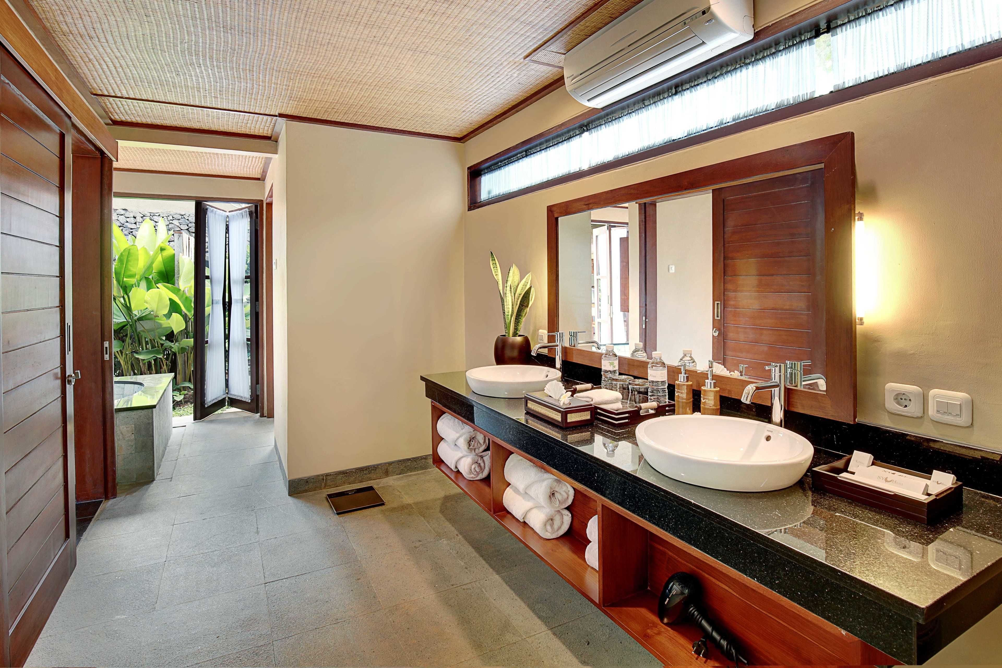 Un baño moderno con dos lavamanos, un espejo grande y un perchero para toallas.