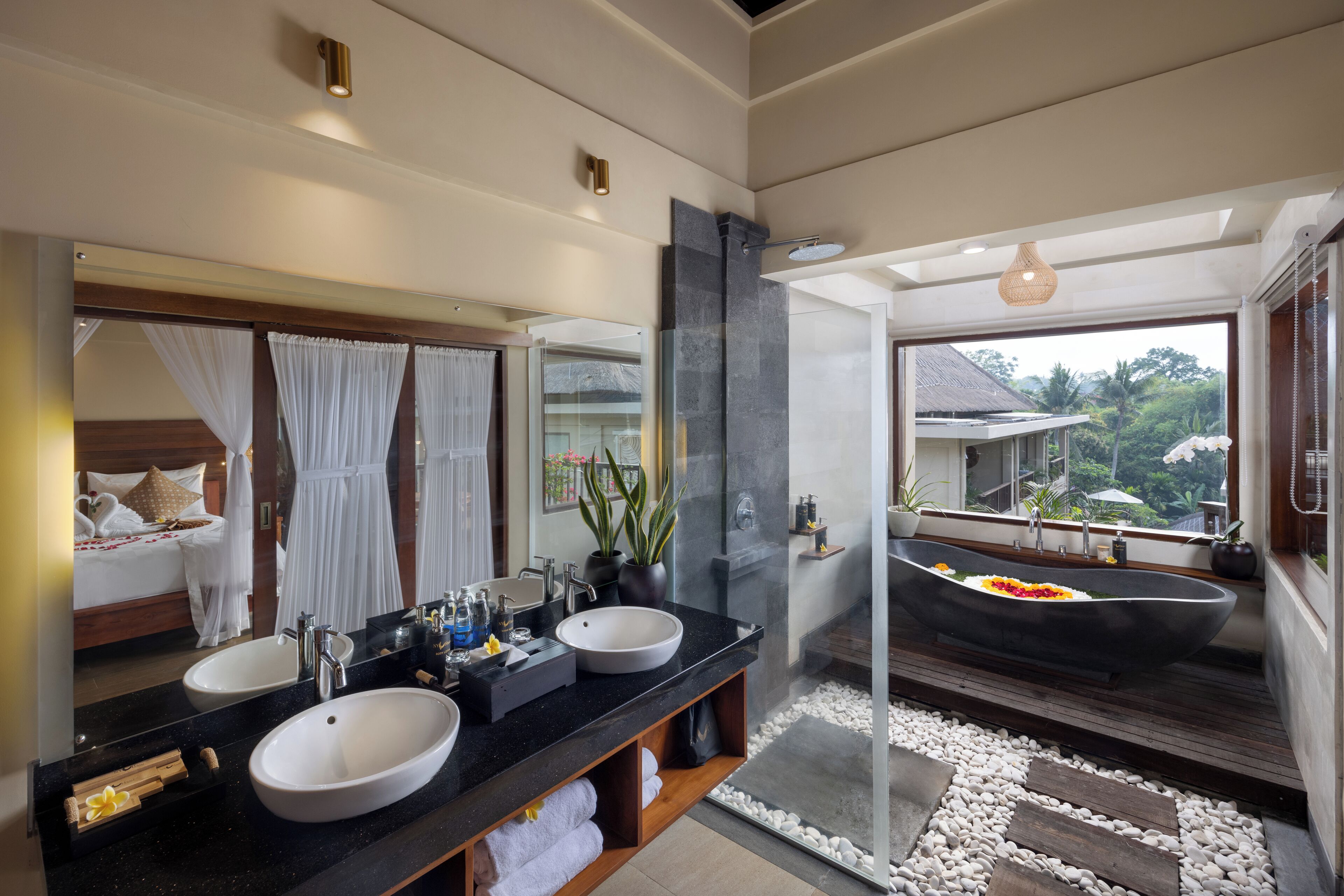 A modern bathroom with dual sinks, a large mirror, and a freestanding bathtub.