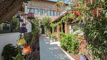 Stroll through the beautifully maintained garden, surrounded by lush greenery and a variety of potted plants.
