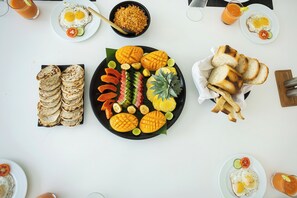 A table with various food items including eggs, toast, and tropical fruits. - Green Turtle Villa by The Serendipity Collection (Kosgoda)
