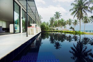 Una piscina al aire libre, sombrillas, sillones reclinables de piscina
