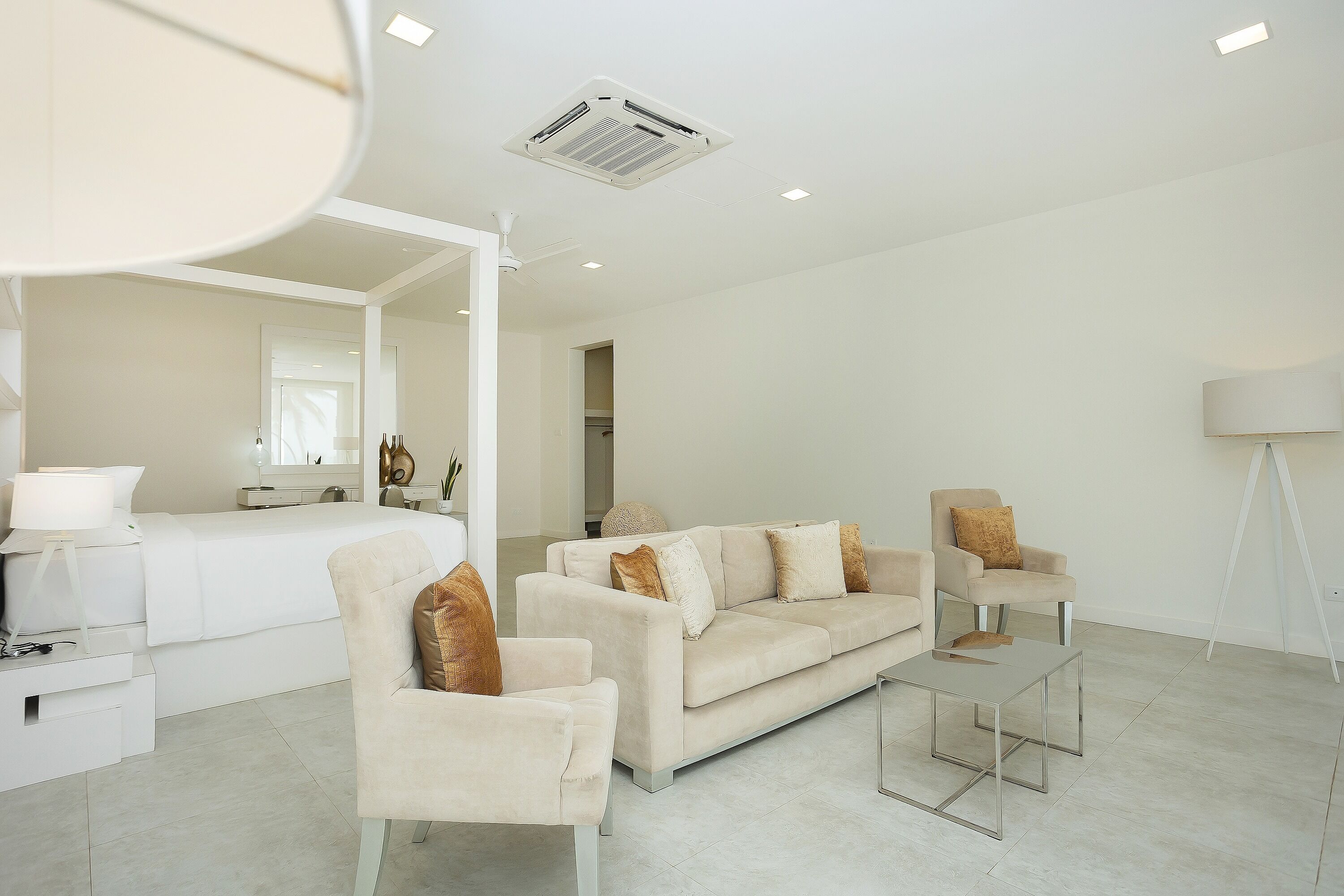 A modern living room with a sofa, chairs, a coffee table, and a floor lamp.