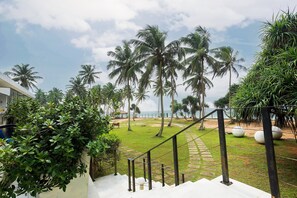 A staircase leading to a grassy area with palm trees and a view of the beach. - Green Turtle Villa by The Serendipity Collection (Kosgoda)