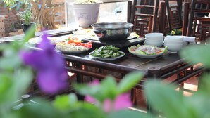 A dining table with various dishes, a large pot, and several bowls. - Tam Coc Craft Homestay (Nam Hoa Lu)