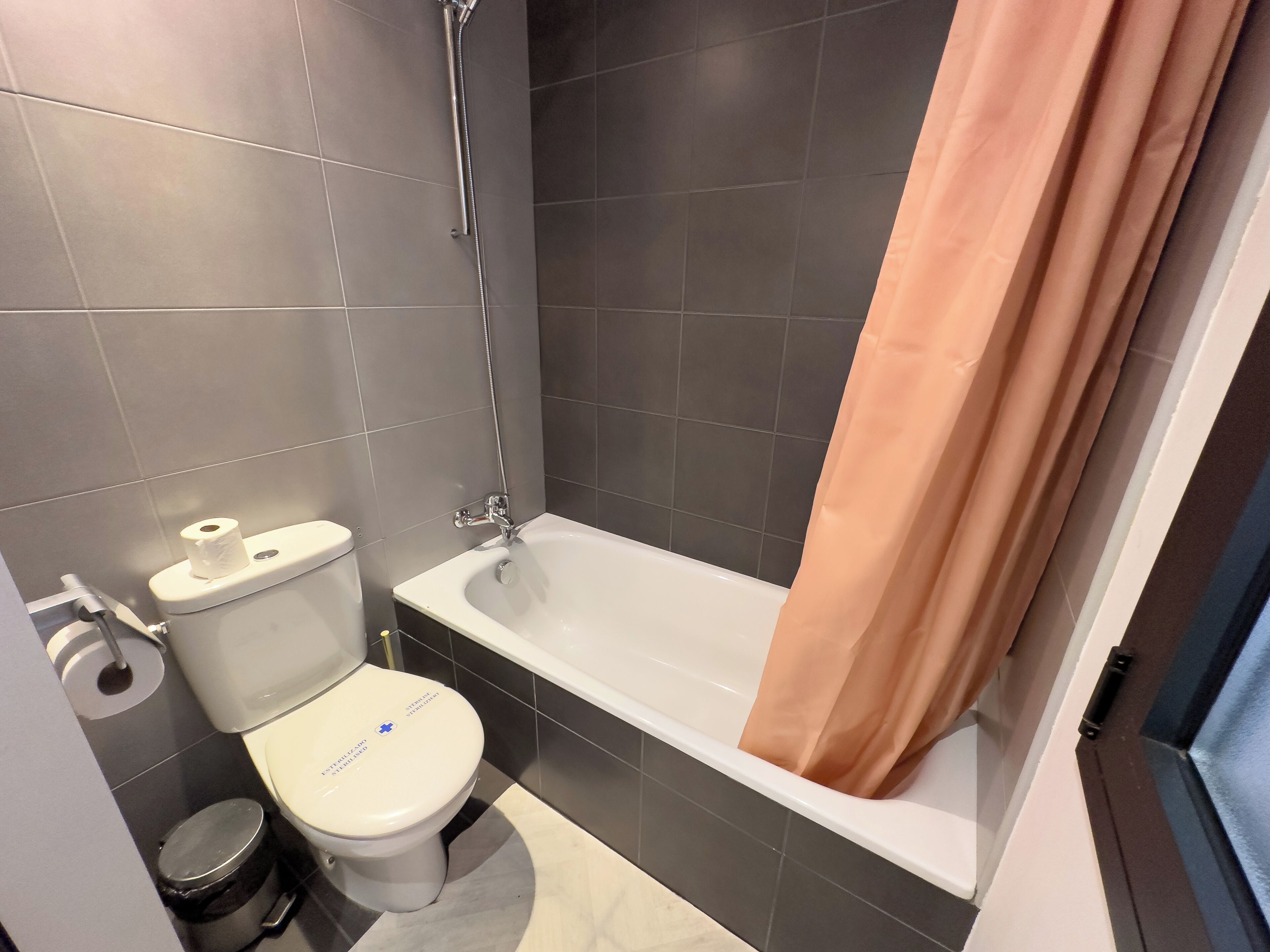 A bathroom with a toilet, a bathtub, and a shower.