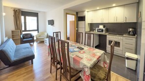 A compact living space with a dining area, kitchenette, and seating.