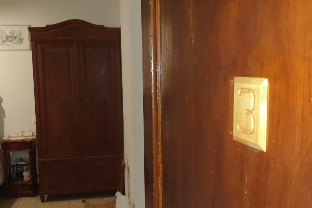 Uma porta de madeira com maçaneta e placa de latão.