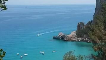 Ranta lähistöllä, aurinkotuoleja, aurinkovarjoja, rantapyyhkeitä