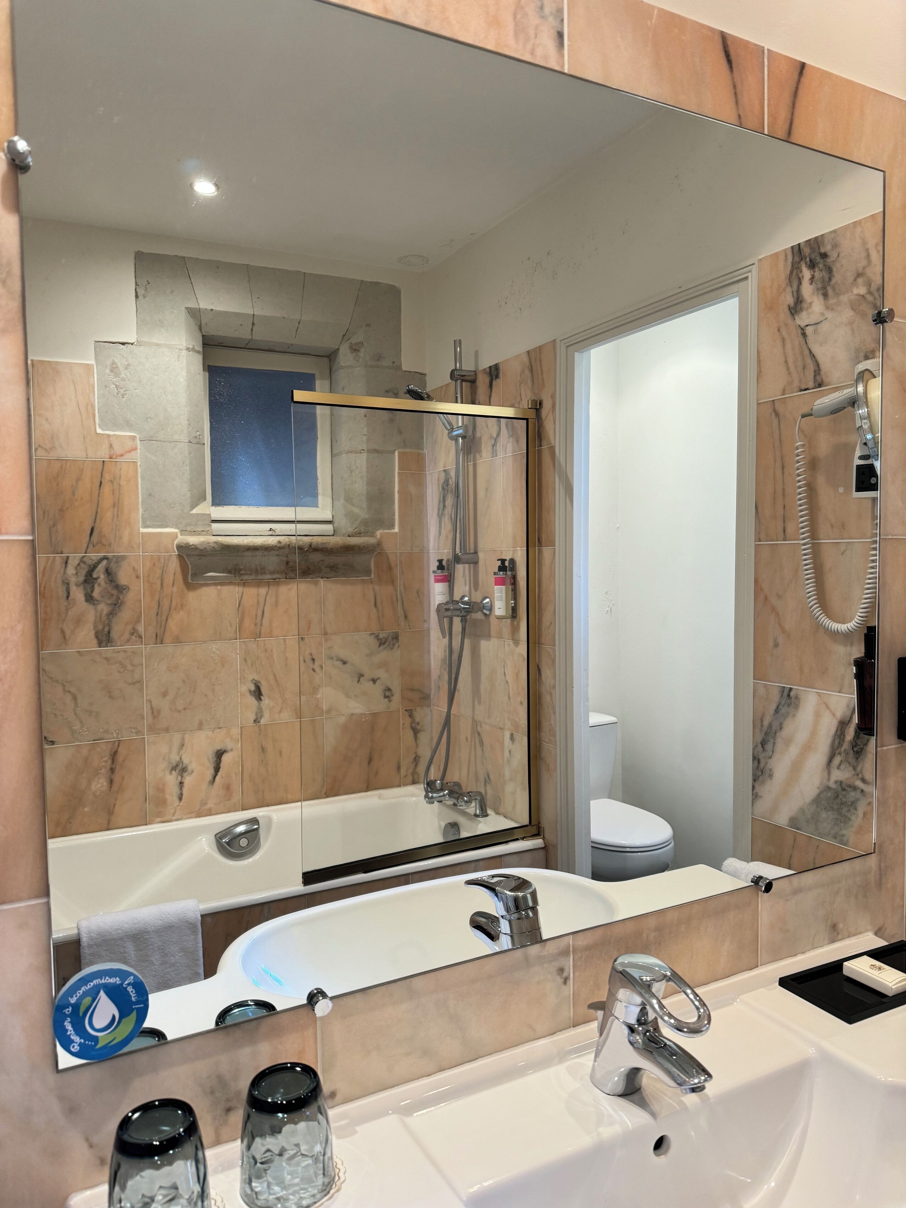 Ein Badezimmer mit großem Spiegel, einer Badewanne, einer Dusche und einem Waschbecken.