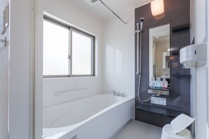 Een aparte badkuip en douche, een bubbelbad, gratis toiletartikelen