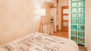 Un dormitorio con una cama, un tocador, una lámpara y una puerta de vidrio verde.