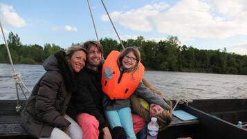 A group of people on a boat with a rope and a bottle of water visible.