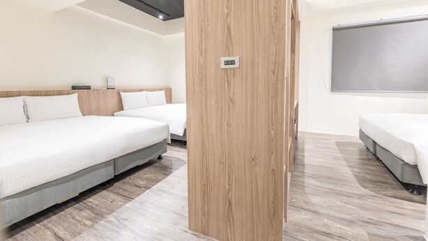 A modern hotel room with two single beds, a wooden accent wall, a large window, and a flat-screen TV. - Traveller Inn Rail Haus (Taitung)