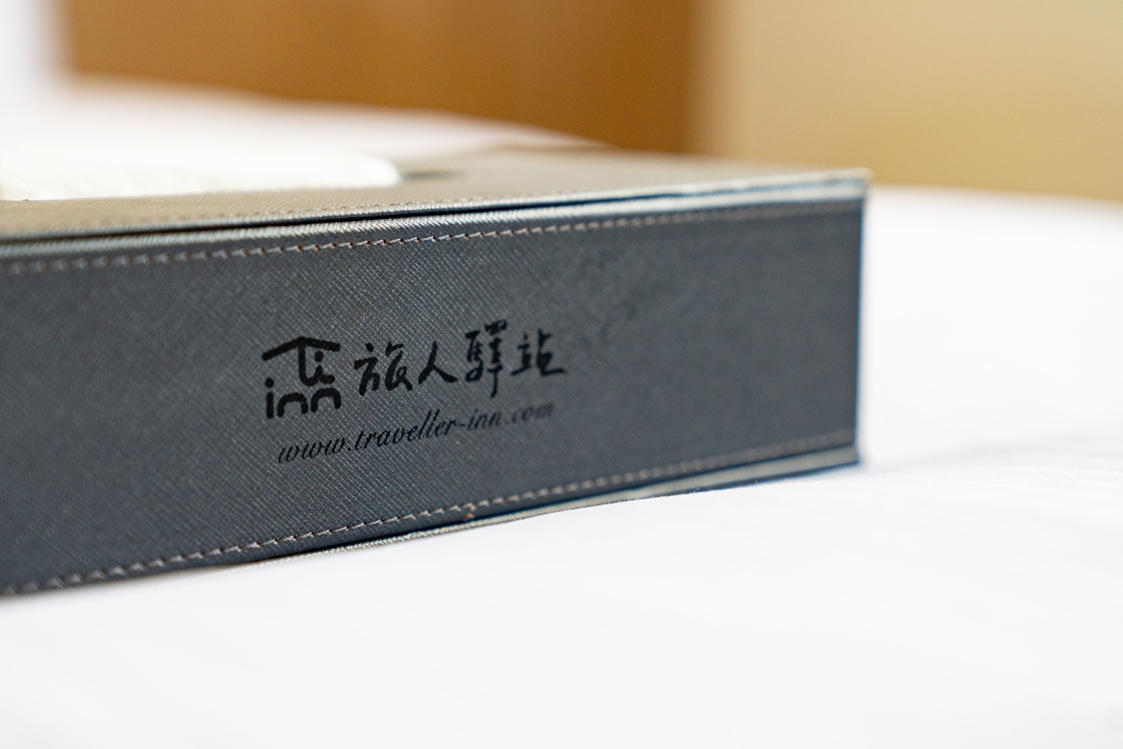 A close-up of a black leather-bound book with Chinese characters and a website URL.