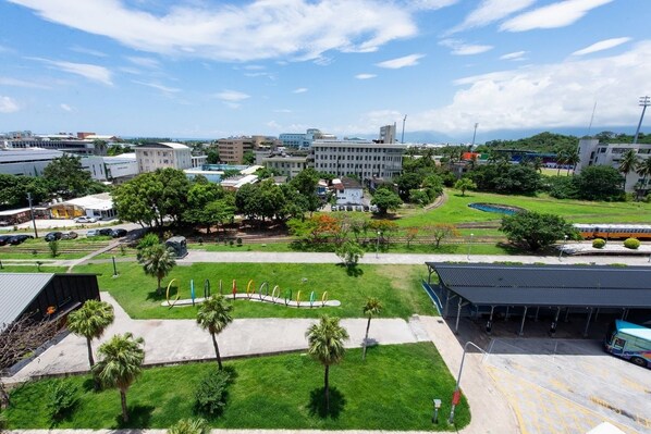 A cityscape with a train station, green spaces, and modern buildings. - Traveller Inn Rail Haus (Taitung)
