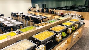 A buffet area with multiple food stations, tables, and chairs. - Traveller Inn Rail Haus (Taitung)