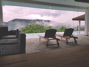 A room with a view of a mountain and a pool. There are two wooden chairs and a woven chair. - Levita (Maberiyatenna)