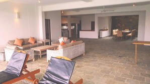 A spacious living area with a large open kitchen in the background, a dining area with chairs, and a seating area with sofas and a coffee table. - Levita (Maberiyatenna)