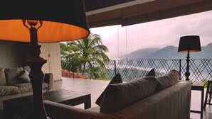 A balcony with a sofa and two lamps, overlooking a mountainous landscape and a body of water. - Levita (Maberiyatenna)