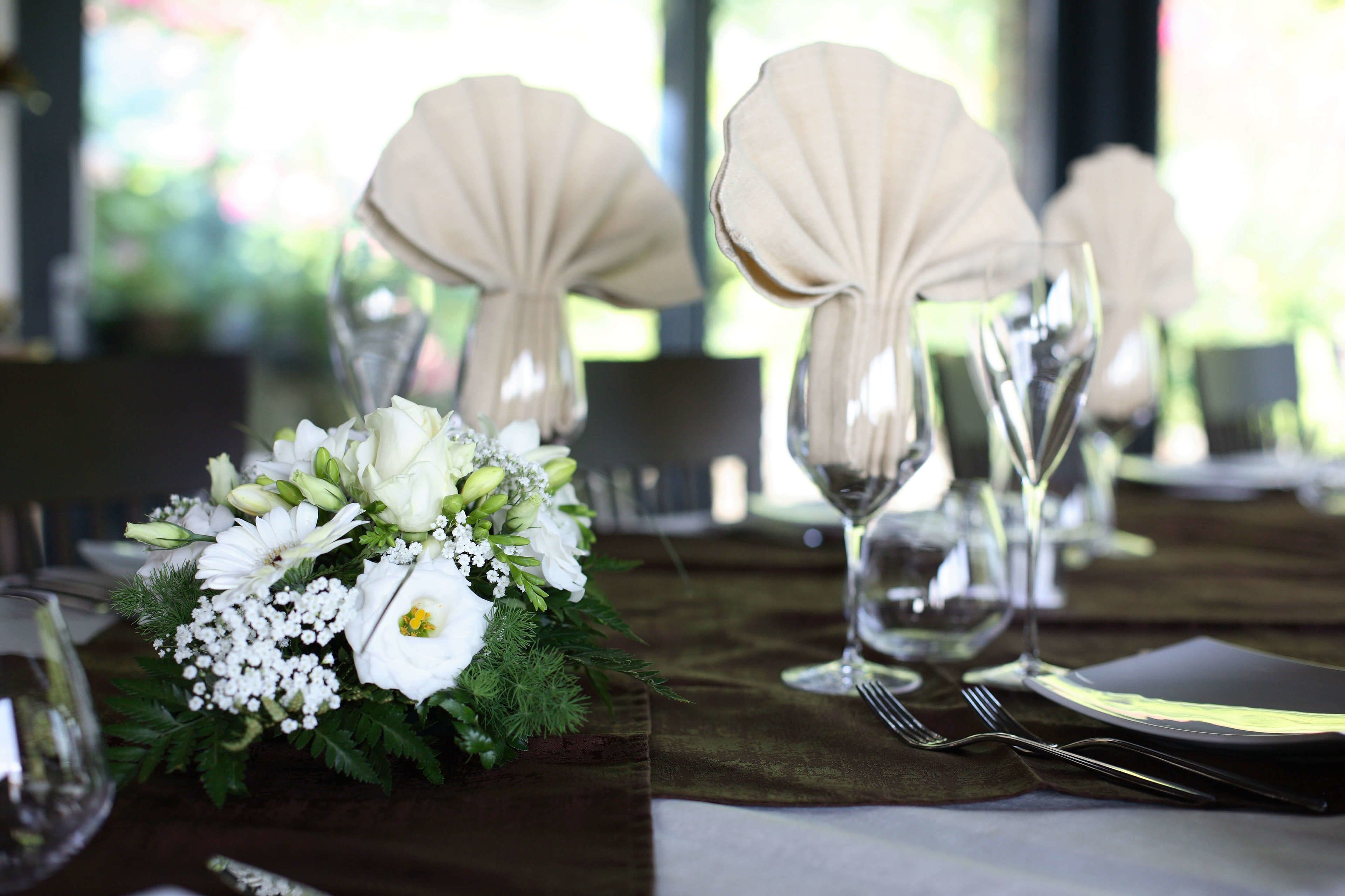 A table set with a floral centerpiece, elegant tableware, and a decorative shell.