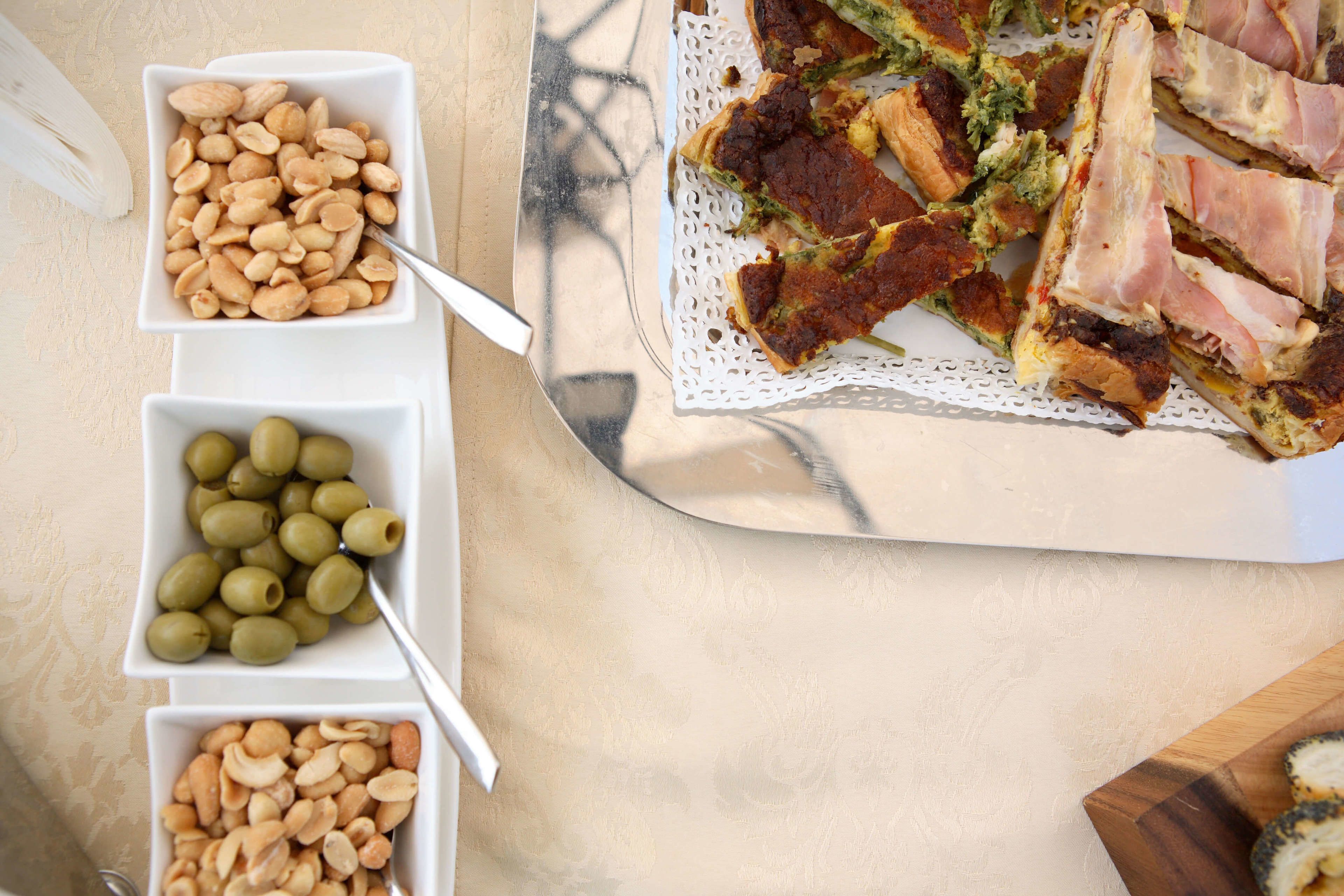 Une table avec une assiette de nourriture, deux bols de noix et un couteau.