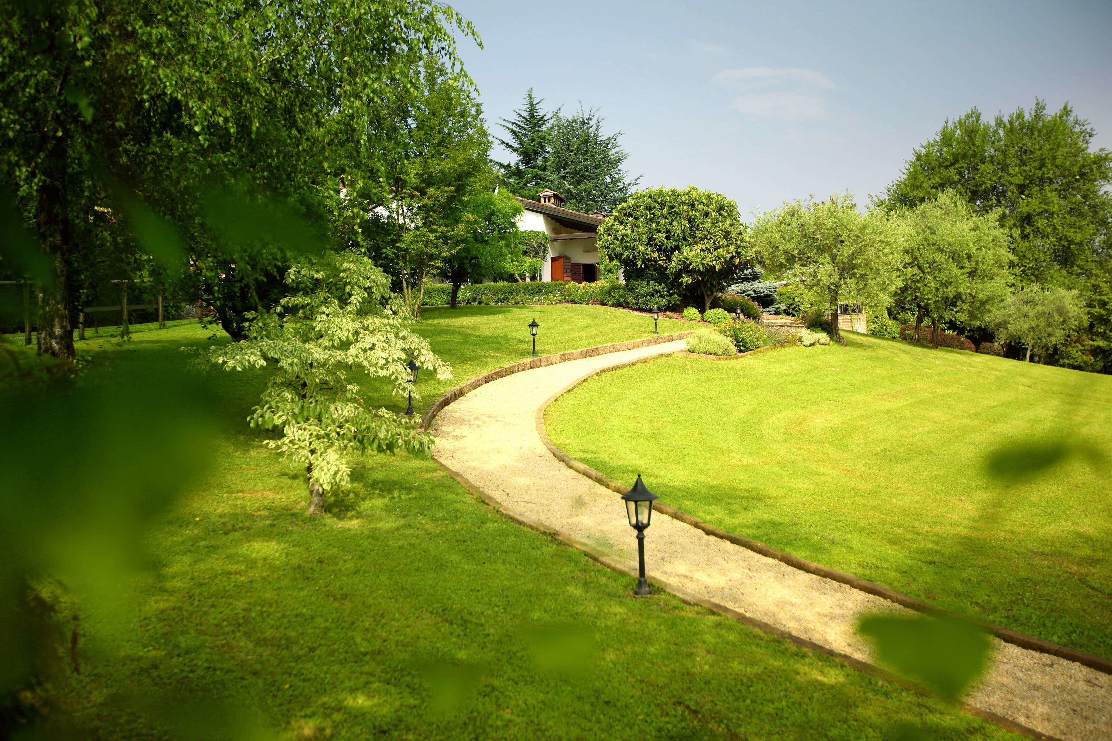Ein gepflegter Garten mit einem gewundenen Weg zu einem Gebäude.