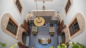 Un interior con suelo estampado, una mesa central y paredes ornamentadas.