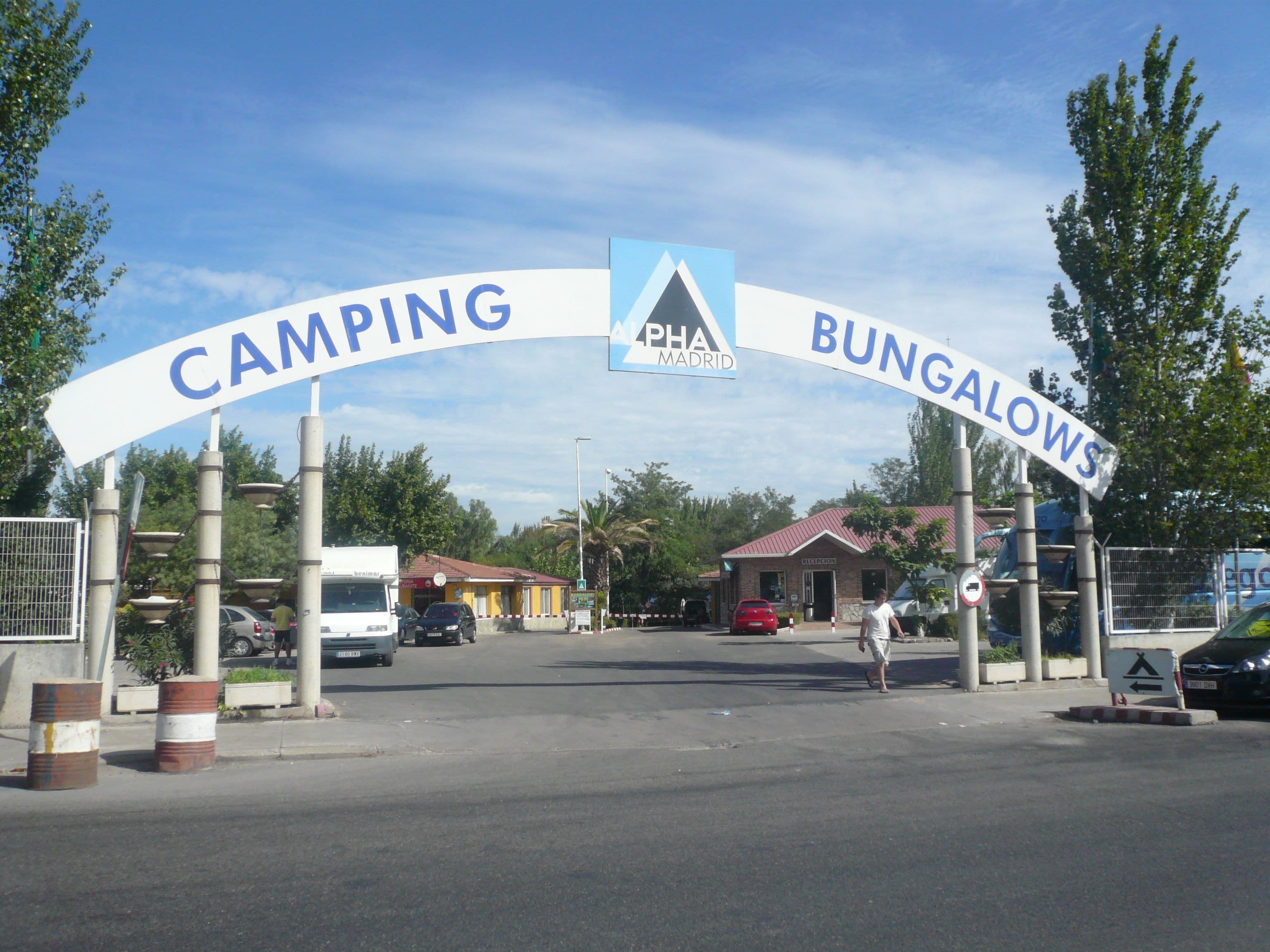 Camino que lleva a una zona de camping y bungalows, con un cartel que indica la dirección.