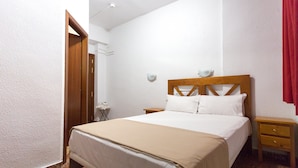 Un dormitorio con cama, mesitas de noche y armario.