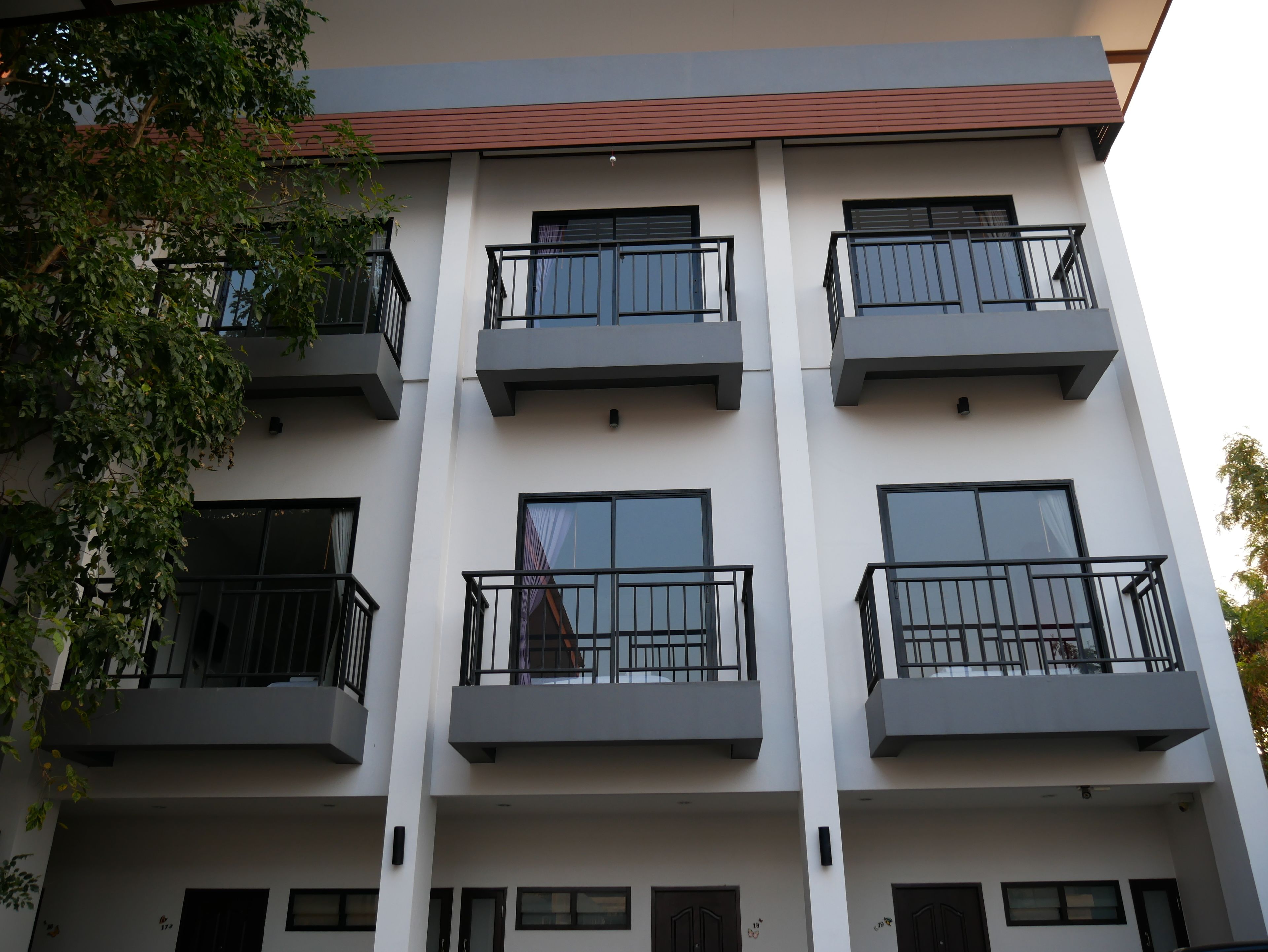 A multi-story building with balconies, large windows, and a flat roof.