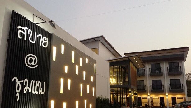 A modern hotel entrance with a large illuminated sign, a covered outdoor area, and a multi-story building with balconies. - Sabai @ Chumphae (Chum Phae)