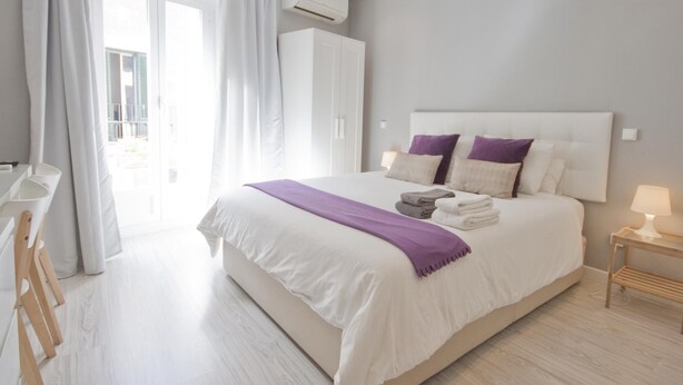 Un dormitorio moderno con una cama grande, un escritorio y un armario.